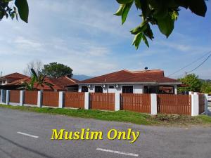 a house with a fence in front of it at Homestay Makyu Kuala Kangsar in Kuala Kangsar