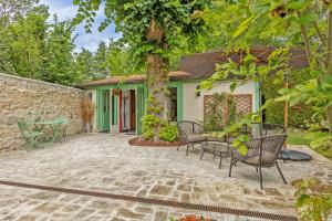 a patio with chairs and a tree in front of a house at L'Orée de Giverny in Limetz