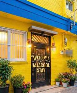 a yellow building with a welcome sign on the door at 자자쿨스테이 in Seoul