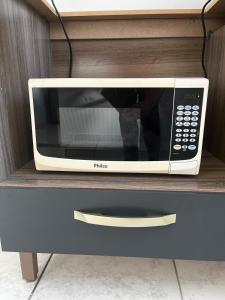 a microwave oven sitting on top of a cabinet at Apto 2 quartos, Wi-Fi rápido, Self check in in Uberlândia
