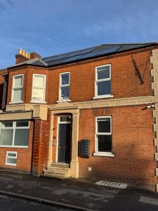 a red brick house with a black roof at Central Aldershot Flat, Near Station & Town Centre in Aldershot