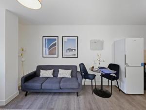 a living room with a blue couch and a table at Regent Circus Apartments in Swindon +78 photos
