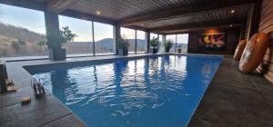 a swimming pool with blue water in a house at La Ferme des Cherrieres - Piscine Intérieure Chauffée in Rupt-sur-Moselle