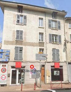 a building on a street with signs in front of it at Cocon du Château, Centre Historique Vizille 7pers in Vizille