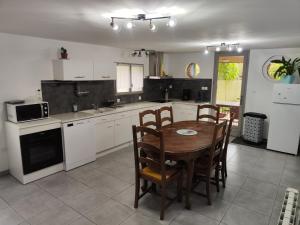 a kitchen with a table and chairs in it at Le gîte des hallais in Bouelles