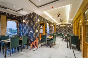 a restaurant with wooden tables and green chairs at The Rising Haveli in Jaisalmer