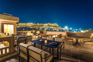 a restaurant with tables and chairs on a balcony at night at The Rising Haveli in Jaisalmer