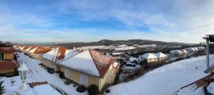 a town with snow covered roofs and houses at Gerecse View Apartman in Dunaszentmiklós