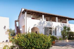 a white house with a bush in front of it at Agriturismo Azzarone in Vieste