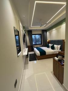 a large bedroom with a bed and a window at Hotel Central Park Inn, in Dehradun