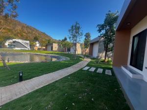 a house with a yard with a pond at The Forest Pool villa & cafe in Ban Wang Yao