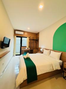 a bedroom with a large bed with a green stripe on it at Saptama Living in Citaringgul 1 +35 photos