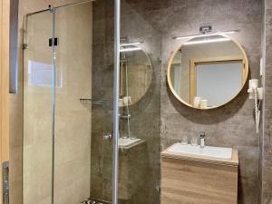 a bathroom with a shower and a sink and a mirror at Bagolyvár Fogadó- Újfalusy Márton Vendégház in Zirc +104 photos