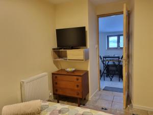 a living room with a television and a dresser with a tv on it at accommodation à la ferme in Lubersac
