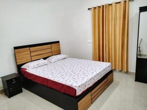 a bedroom with a bed with a wooden headboard at Spring Dale Homestay in Thekkady