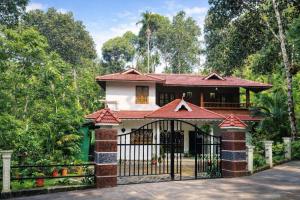 a house with a gate and a fence at Spring Dale Homestay in Thekkady