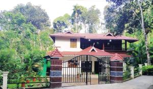 a house with a gate in front of it at Spring Dale Homestay in Thekkady