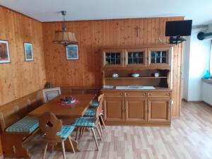 a kitchen with wooden walls and a table and chairs at Casa Milpa in Sappada