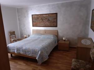 a bedroom with a bed and a painting on the wall at Casa Milpa in Sappada