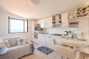 a kitchen with a couch and a table in a room at Lovely Flat with See View in Roseto degli Abruzzi
