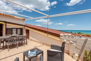 a patio with a table and chairs and the ocean at Lovely Flat with See View in Roseto degli Abruzzi