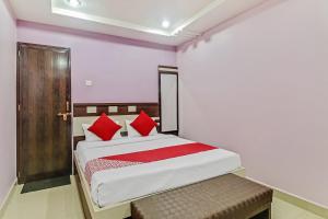 a bedroom with a large bed with red pillows at Hotel O Royal in Rāj Nāndgaon