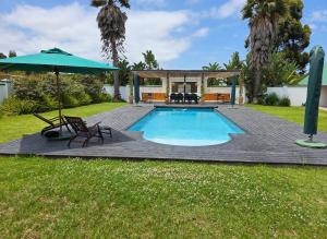 a swimming pool with a deck and an umbrella at L'Heritage Retreat in Wildernis
