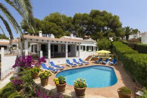 a house with a swimming pool and chairs and trees at Villa Maite by Escape Home in Binibeca
