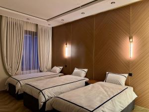 a hotel room with two beds and a window at Hotel VANGOGH in Kyzylorda
