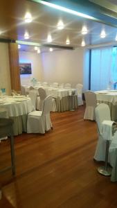 une salle de banquet avec des tables blanches et des chaises blanches dans l'établissement Hotel Isla Bella & Spa, à Isla