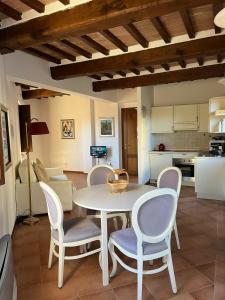 a living room with a table and chairs and a kitchen at Chianti Borgo 28 in Gaiole in Chianti