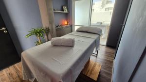 dwa łóżka w małym pokoju z oknem w obiekcie DAKAR HOTEL w mieście Mendoza +53 zdjęcia