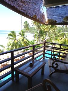 a balcony with a table and a view of the ocean at Paradise Beach Club in Mirissa