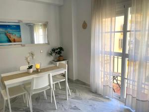 a white dining room with a table and a window at Beach Side Heaven in Fuengirola