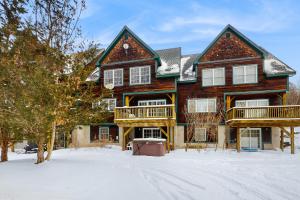 a large wooden house with snow on the ground at Grouse Lane 12C in Dover