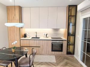a kitchen with a table and a dining room at Downtown Shkodra Apartment in Shkodër