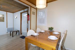 a dining room with a wooden table and chairs at Camping Domaine Papillon in Reyrevignes