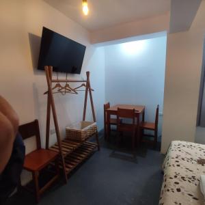 a room with a television on a stand with a table at Hospedaje Velilu in Ica