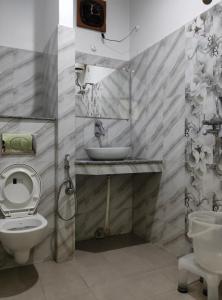 a bathroom with a sink and a toilet and a mirror at Hotel Hari mangalam heritage in Tehri-Garhwāl +133 photos