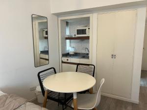 a small kitchen with a table and chairs in a room at Apart hotel Ciudad de Bs As in Buenos Aires