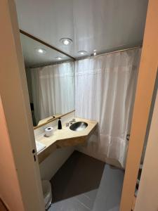 a bathroom with a sink and a shower curtain at Apart hotel Ciudad de Bs As in Buenos Aires +31 photos
