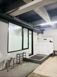 a room with two stools and a large window at Saptama Living in Citaringgul 1