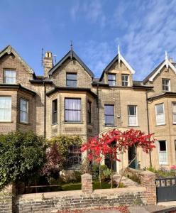 a large brick house with a tree in front of it at Suffolk Coast Townhouse in Pakefield