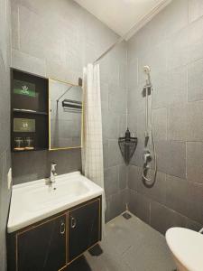 a bathroom with a sink and a shower at Saptama Living in Citaringgul 1