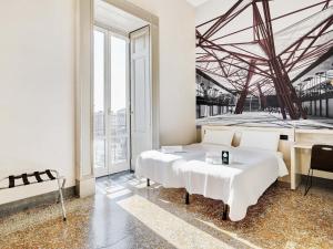 a white bedroom with two beds and a desk at B&B Hotel Napoli in Naples