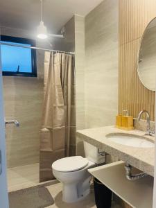 a bathroom with a toilet and a shower and a sink at Apartamento moderno no Centro de Cabo Frio in Cabo Frio