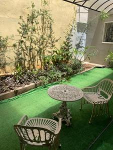 a patio with a table and chairs on a green lawn at Hotel Prudente RP in Ribeirão Preto