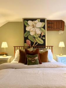 a bedroom with a bed with a flower painting on the wall at Staneve Cottage in Docking