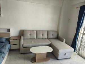 a small living room with a couch and a table at nirun condo 238 in Pattaya