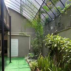 an indoor garden with plants and a glass ceiling at Hotel Prudente RP in Ribeirão Preto